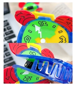 Detail view showing a colorful clock-shaped acetate hair claw clip with gear details