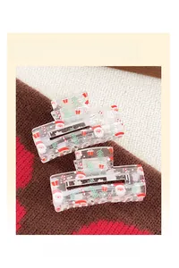 Detail of transparent hair claw clip featuring Santa Claus and Christmas tree patterns