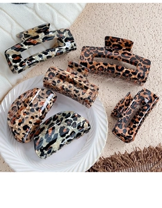 Detailed close-up of various leopard print hair claws in rectangular and round shapes