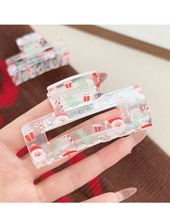 Detail of transparent acrylic Christmas hair claw clip with Santa Claus and festive prints