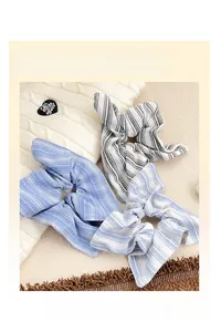 Détail de chouchous rayés bleu et noir avec texture plissée sur un tricot doux