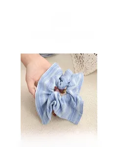 Gros plan du chouchou en tissu à rayures bleues et blanches avec détails plissés doux