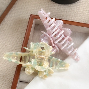 Floral hair claw set with pink marble and yellow patterns in a wooden tray