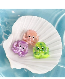 Cute octopus hair clips in pink, purple, and green colors displayed inside a seashell