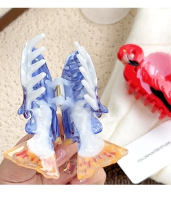 Close-up of a blue marble texture fish-shaped hair claw made of acetate material