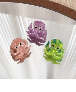 Detailed close-up of octopus-shaped acetate hair claws in pink, purple and yellow