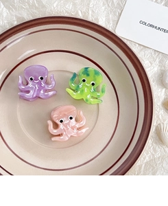 Detail of octopus cellulose acetate hair clips in purple, marble green, and pink colors