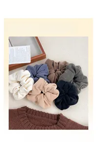 Detail showing a set of six soft plush scrunchies in assorted warm autumn colors