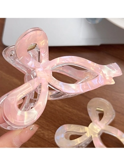 Détail de la pince à cheveux nœud rose nacré avec texture coquille et ressort métal