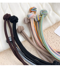Close-up of elastic hair bands with knitted knot details in various neutral colors