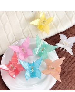 Close-up of butterfly acrylic hair claws in multiple pastel colors and translucent textures