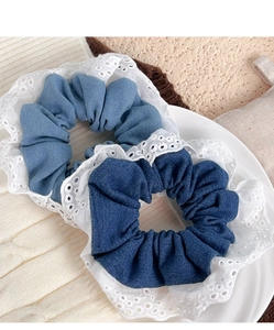Detailed view of light and dark blue denim scrunchies with elegant white lace edges