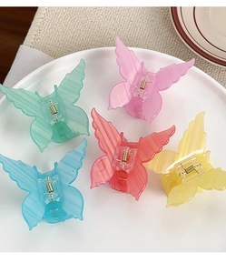 Set of five butterfly hair claws in jelly colors displayed on a white plate
