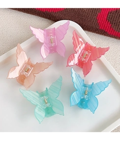 Set of five acrylic butterfly hair clips in translucent pastel marble colors on tray