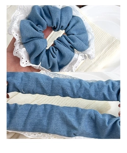 Detail of blue denim scrunchie with white lace trim showing its high elastic stretch feature