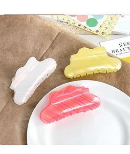 Gros plan sur des pinces à cheveux nuages nacrées en blanc, jaune et rose corail