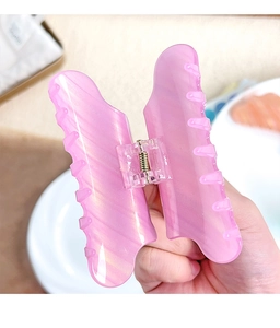 Détail de la pince à cheveux papillon rose nacré avec ressort métallique robuste