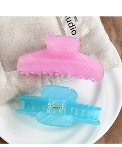 Detail of pink striped and blue translucent acrylic hair claws with gold springs