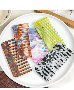Detailed close-up of wide-tooth marble acetate hair combs in five elegant colors