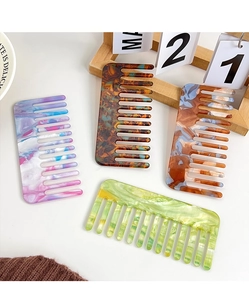 Detail view of wide-tooth acetate combs in marble patterns and tortoiseshell finish