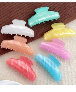 Close-up of a 7-piece set of French striped acrylic hair claw clips in various pastel colors