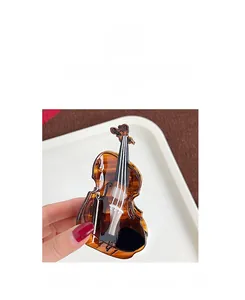 Detailed close-up of a violin-shaped hair claw clip in elegant amber tortoiseshell finish