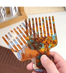 Macro detail of marbled acetate hair combs showing translucent texture and fine teeth