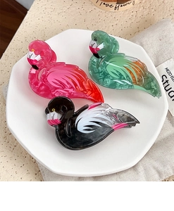 Detailed trio of flamingo-shaped acrylic hair claws with marble texture in vibrant colors