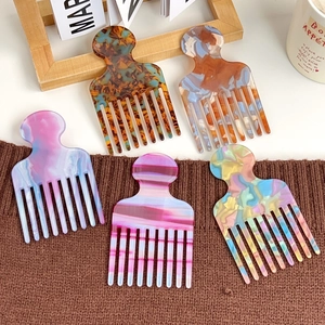 Five assorted marble pattern acetate hair combs set on a warm aesthetic background