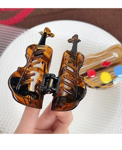 Detail of cello shaped hair claw clip in amber tortoiseshell acetate with sturdy metal spring