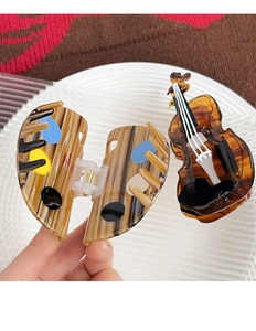 Detailed macro view of cello and palette shaped acetate hair claws on a textured background