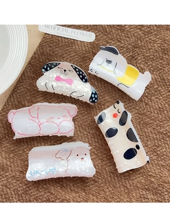 Set of five pearlescent acrylic hair claws with cute cartoon dog designs on fabric