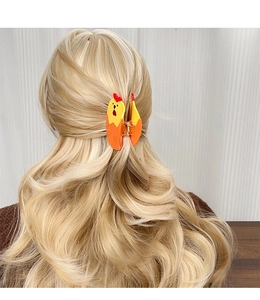 Vue détaillée arrière d'une pince à cheveux mignonne en forme de coq jaune et orange