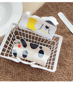 Detailed view of two cartoon dalmatian dog hair claws in a white wire storage basket