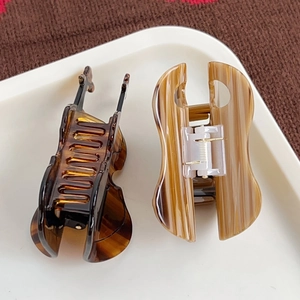 Vintage cello-shaped cellulose acetate hair claws in tortoise and wood grain finishes