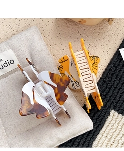 Close-up of acetic acid tiger print and tortoiseshell butterfly hair claw clips