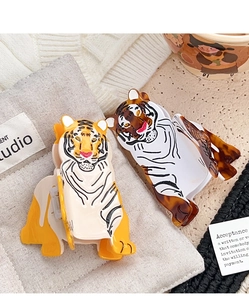 Detail view of tiger-shaped acetate hair claws in yellow and dark brown colors
