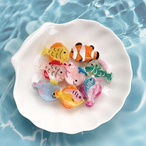 Mini sea fish acetate hair clips for girls in various ocean colors on a white shell tray