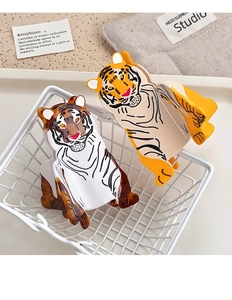 Detail view of tiger shaped acetate hair claws in white and yellow colors inside a basket