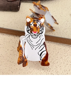 Detail of tiger-shaped acetate hair claw clip with brown tortoiseshell texture and metal spring