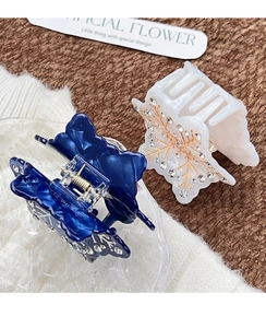 Dettaglio di fermagli per capelli a farfalla con strass a fiocco di neve blu e crema