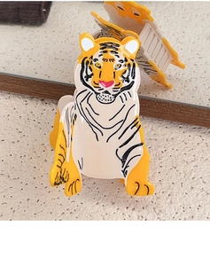 Detailed view of creative acetate tiger hair claw clip with polished finish on mirror