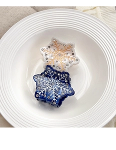 Dettaglio di fermagli per capelli a fiocco di neve in acetato blu e bianco con strass lucidi