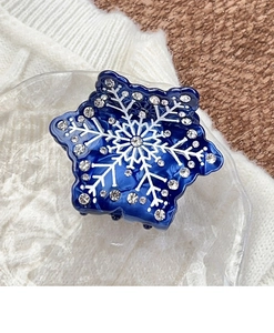 Dettaglio di un fermaglio per capelli a fiocco di neve in acetato blu con strass lucidi