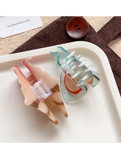 Detail view of acetate marble and translucent hair claws on a decorative tray