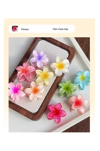 Détail de pinces à cheveux en résine en forme de fleur de frangipanier aux tons pastel