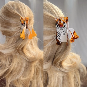 Acetate tiger hair claw clips in yellow and tortoise patterns on blonde model