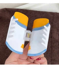 Détail d'une pince à cheveux créative en forme de basket avec design coloré en acétate poli