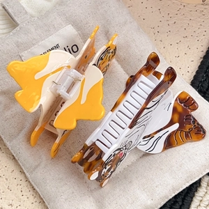 Chic acetate tiger claw clips in yellow and white patterns for creative hairstyling
