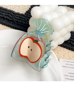 Detail of translucent light blue acetate hair claw clip with sliced apple pattern